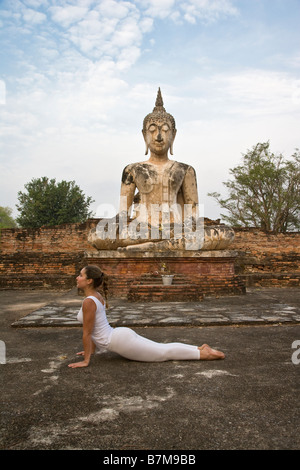 Yoga, Frau, Buddha, beim Yoga vor Denkmal, Sakralraum, Yogi, Yoga-Pose, zurück biegen, glückliches, gesundes, gut sein, weisen Stockfoto