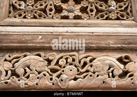 Hölzerne Carvings auf eine Tür am Chenghuang Miao Tao Tempel in Xian in China. Stockfoto