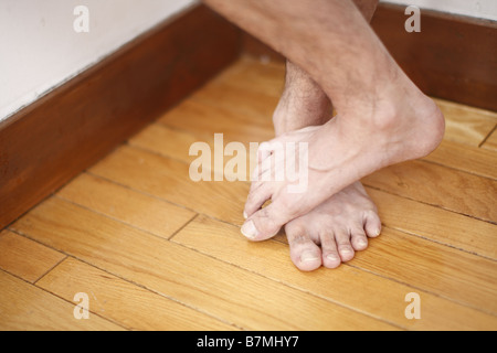 Füße auf Holzboden Stockfoto