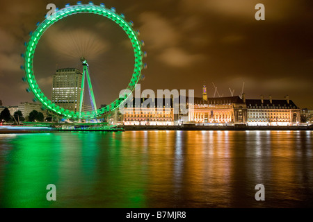 London Eye und die County Hall Gebäude spiegelt sich in der Themse bei Nacht Stockfoto