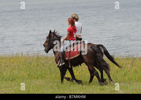 Outdoor-Foto von zwei jungen Mädchen reiten auf den Pferden Stockfoto