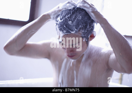 Mann Waschen Haare in der Dusche Stockfoto