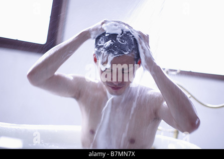 Mann Waschen Haare in der Dusche Stockfoto