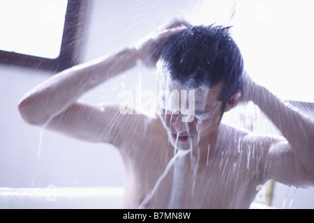 Mann Waschen Haare in der Dusche Stockfoto