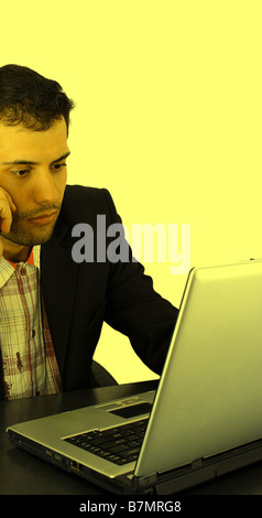 Geschäftsmann, arbeiten am Laptop isoliert auf gelb Stockfoto