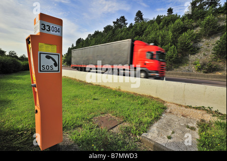 Notruftelefon auf einer französischen Autobahn mit einem LKW vorbei. Bewegungsunschärfe auf dem LKW. Stockfoto