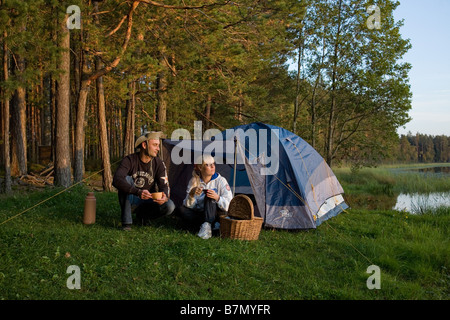 Junges Paar sitzt vor dem Zelt Põlva Grafschaft Meenikunno Landschaft Reserve Estland Stockfoto
