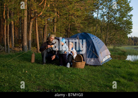 Junge Familie sitzt vor dem Zelt Põlva Grafschaft Meenikunno Landschaft Reserve Estland Stockfoto