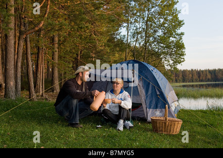 Junges Paar sitzt vor dem Zelt Meenikunno Landschaft Reserve Põlva County Estland Stockfoto