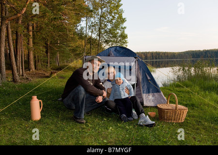 Junge Familie sitzt vor dem Zelt Meenikunno Landschaft Reserve Põlva County Estland Stockfoto