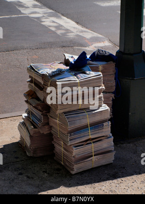 Zeitungen zum Vertrieb oder zur Lieferung an einer New Yorker Straße Ecke gestapelt. Stockfoto