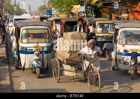 Eine typische chaotischen Straßenszene in Varanasi mit Fahrrad- und Auto-Rikschas (Tuk Tuks) auf den belebten Straßen. Stockfoto