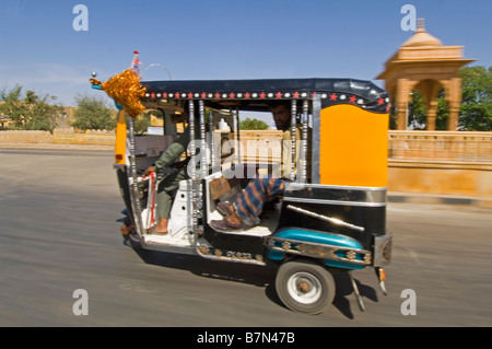 Eine verzierte gelben und schwarzen Auto-Rikscha (Tuk Tuk) und Passagier genommen von einem anderen mit langsamen Verschlusszeit für Bewegung verwischen. Stockfoto