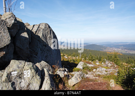 Wandern in Modrava, Tschechische Republik. Felsbrocken umrahmen den Herbst gefärbten Wald. Stockfoto