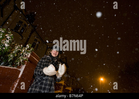 Eine Mädchen spielt Schneebälle in der Nacht bei starkem Schneefall Regengüssen im Zentrum von London, ein seltenes Ereignis für eine südliche Innenstadt Stockfoto