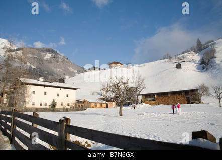 Rauris Österreich EU Januar Blick auf landwirtschaftlichen Flächen rund um das Ski-Resort-Stadt mit ein paar Mädchen, die einen Schneemann bauen Stockfoto