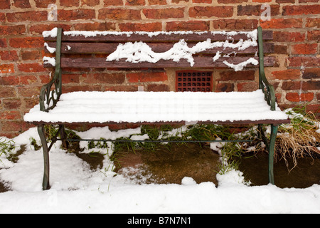 Alte Garten-Sitzplatz im Schnee in einem englischen Garten im Winter überdacht Stockfoto