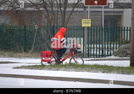 Postbote auf Fahrrad im Schnee, Warwick, Warwickshire, England, UK Stockfoto