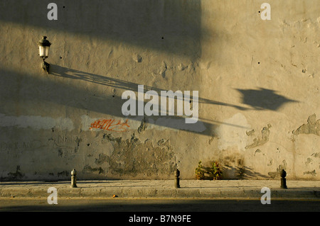 Abendsonne wirft lange Schatten an der Wand, Granada, Andalusien, Spanien. Stockfoto