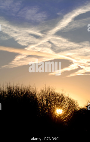 KONDENSSTREIFEN BILDEN EIN INTERESSANTES MUSTER ÜBER DEN MORGENHIMMEL IN WILTSHIRE UK Stockfoto