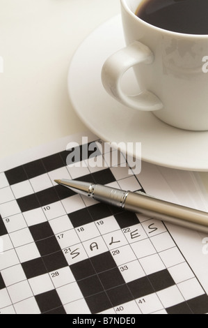 Stift auf Kreuzworträtsel mit Antwort Vertrieb geschrieben, Tasse schwarzen Kaffee oben rechts liegend Stockfoto