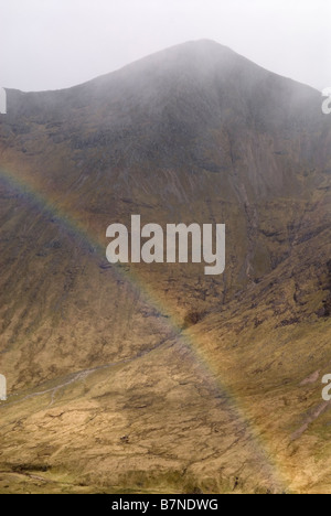 Regenbogen im Lairig Gartain als Schneesturm übergeht Buachaille Etive Mor Ridge, Glen Coe, Lochaber, Schottland, Mai Stockfoto