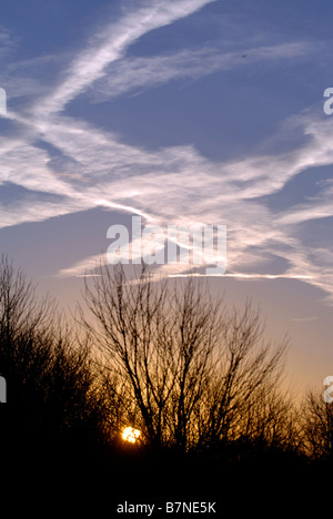 KONDENSSTREIFEN BILDEN EIN INTERESSANTES MUSTER ÜBER DEN MORGENHIMMEL IN WILTSHIRE UK Stockfoto