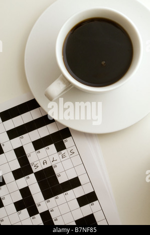 Kreuzworträtsel mit Antwort geschrieben, Tasse schwarzen Kaffee oben rechts, gedreht von oben Stockfoto