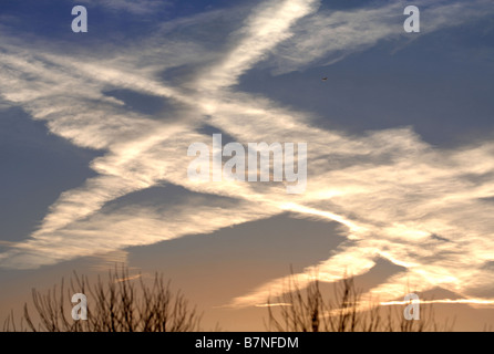 KONDENSSTREIFEN BILDEN EIN INTERESSANTES MUSTER ÜBER DEN MORGENHIMMEL IN WILTSHIRE UK Stockfoto