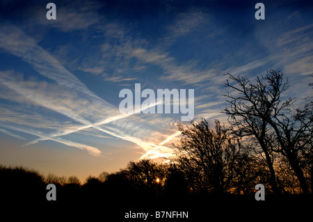 KONDENSSTREIFEN BILDEN EIN INTERESSANTES MUSTER ÜBER DEN MORGENHIMMEL IN WILTSHIRE UK Stockfoto