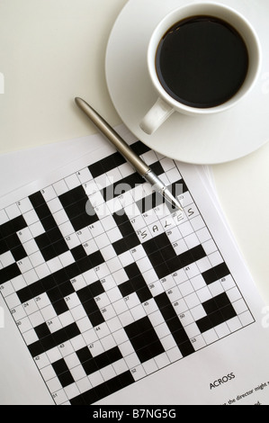 Stift liegen oben auf Kreuzworträtsel mit Antwort geschrieben, Tasse schwarzen Kaffee oben rechts, von oben geschossen Stockfoto