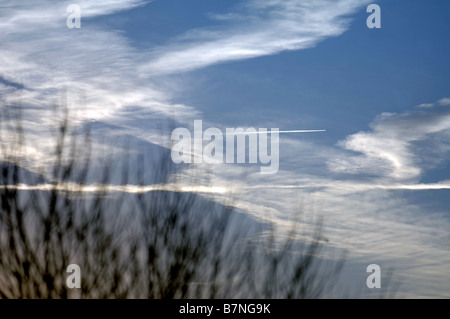 KONDENSSTREIFEN BILDEN EIN INTERESSANTES MUSTER ÜBER DEN MORGENHIMMEL IN WILTSHIRE UK Stockfoto