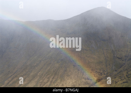 Regenbogen im Lairig Gartain als Schneesturm übergeht Buachaille Etive Mor Ridge, Glen Coe, Lochaber, Schottland, Mai Stockfoto