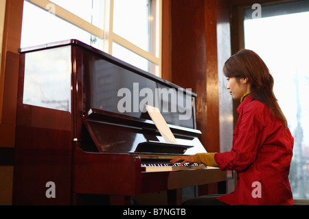 Junge Frau mit dem Klavierspiel Stockfoto