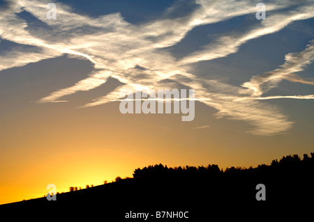 KONDENSSTREIFEN BILDEN EIN INTERESSANTES MUSTER ÜBER DEN MORGENHIMMEL IN WILTSHIRE UK Stockfoto