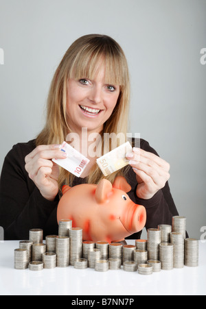 Junge Frau mit einem Sparschwein Stockfoto