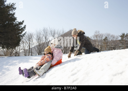 Vater und Kinder beim spielen, Rodeln Stockfoto