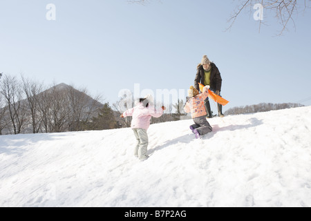 Vater und Kinder beim spielen, Rodeln Stockfoto