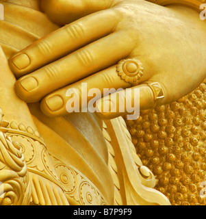 Die Hand eine goldene Buddhastatue Stockfoto