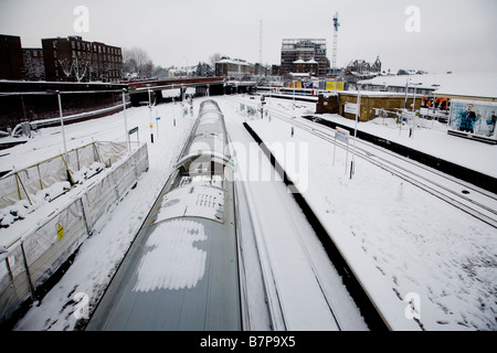 Schnee und dem Zug am Bahnhof Clapham Junction Stockfoto