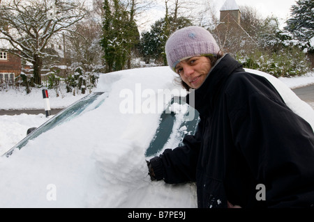 Frau ihr Schnee von ihrem Auto Reinigung Stockfoto