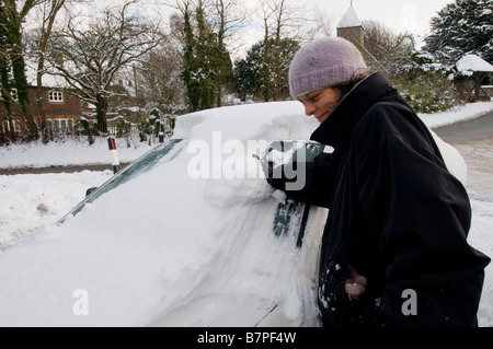 Frau ihr Schnee von ihrem Auto Reinigung Stockfoto