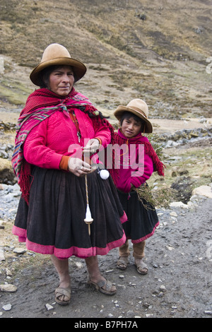 Eine Quechua-Frau, Alpakawolle Spinnen stellt mit ihrer Tochter auf die Spur zu Q'eros. Stockfoto