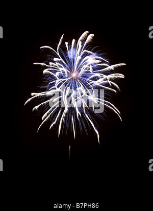 Ein Feuerwerk explodiert in den Nachthimmel. Platz für Text in der Dunkelheit des Himmels. Stockfoto