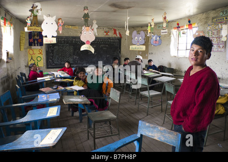 Die Schüler warten herum, während der Lehrer in der kleinen Grundschule in Q'eros die jüngeren Kinder betreut. Stockfoto