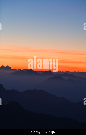 Julischen Alpen gesehen von Mangrt in Slowenien dunklen Bergen in Vordergrund mit reichen orange Sonnenuntergang zum Horizont und vor Stockfoto