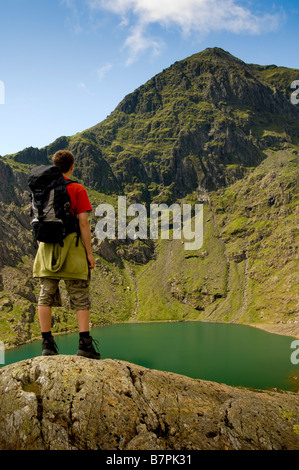 Gipfel des Mount Snowdon mit männlichem Wanderer im Vordergrund, der auf den Gipfel blickt. Stockfoto