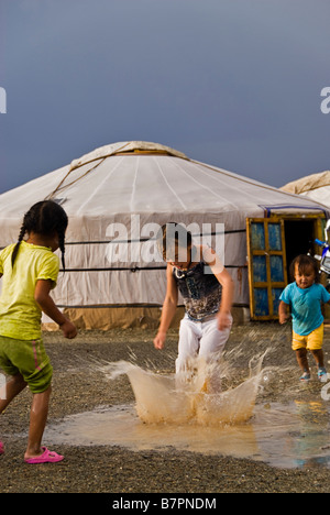 Mädchen spielen mit ihren Jurten unter dem Regen während eines Sturms in der Wüste Gobi, Mongolei Stockfoto