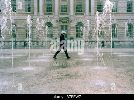 Mann zu Fuß durch Brunnen am Somerset House, London, England, UK Stockfoto