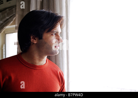Seitenansicht eines Mannes Blick durch ein Fenster Stockfoto